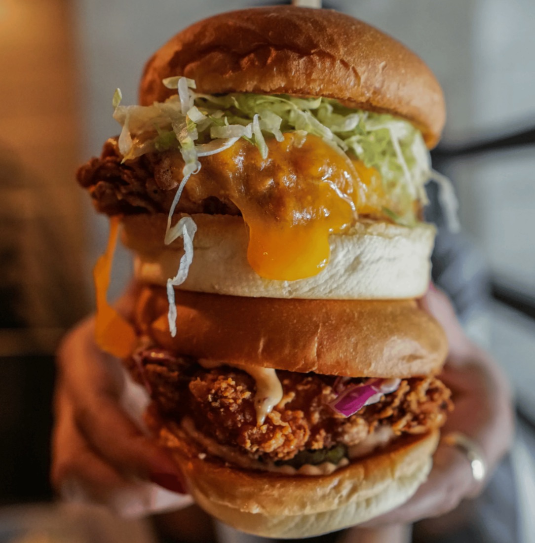Chicken Burger mit knusprigem Hähnchen, Käse, Salat und roten Zwiebeln
